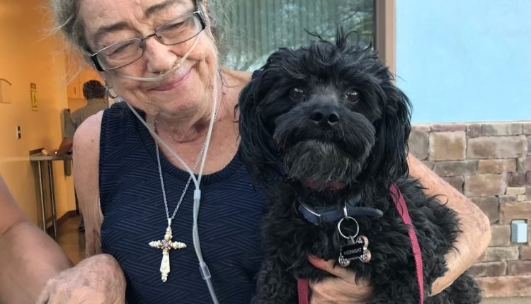 A mother and son stood in the hall of a shelter, hugging their dog and crying